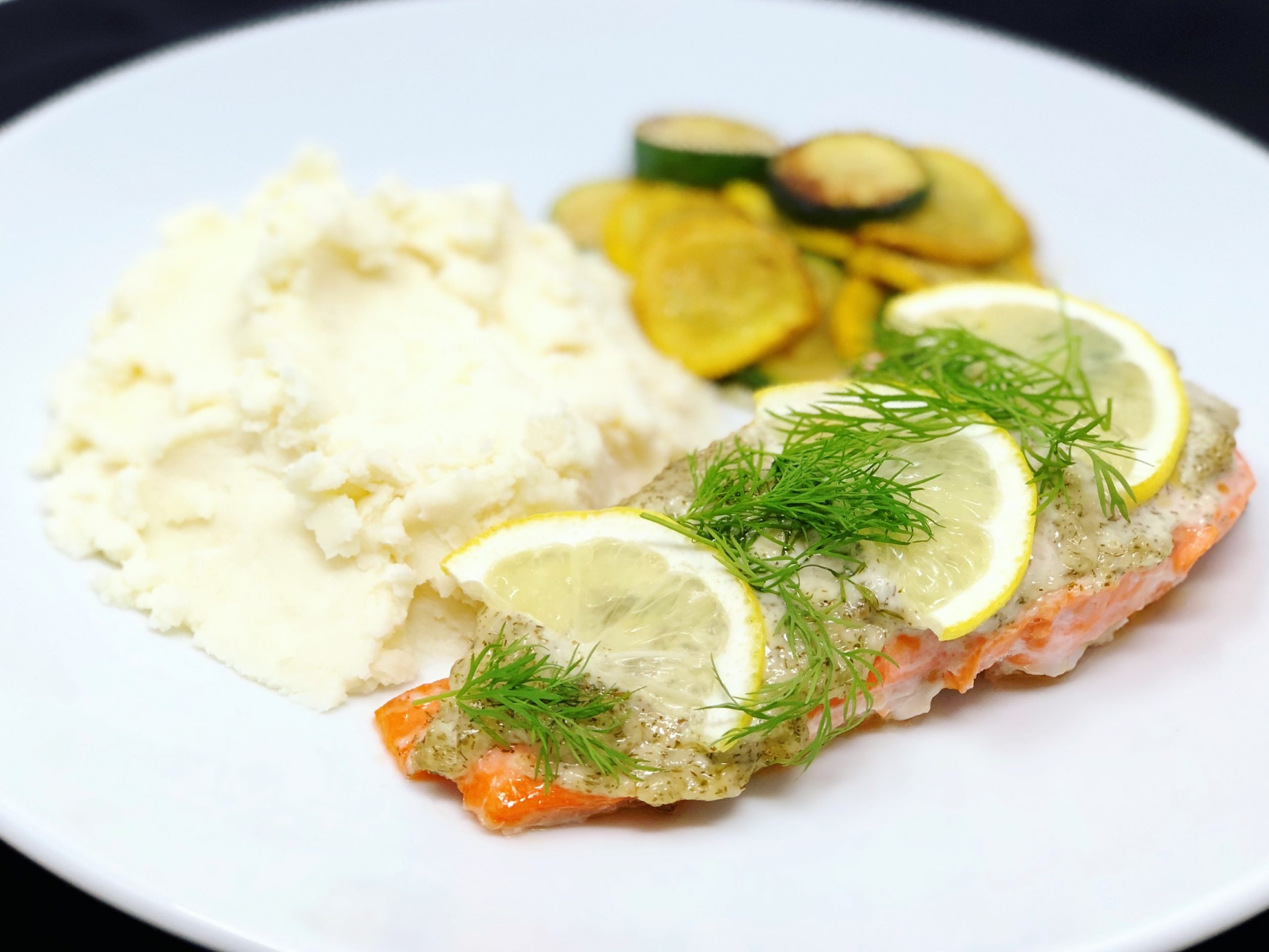 Dish of Baked Salmon with Dill Garlic Spread and Lemon