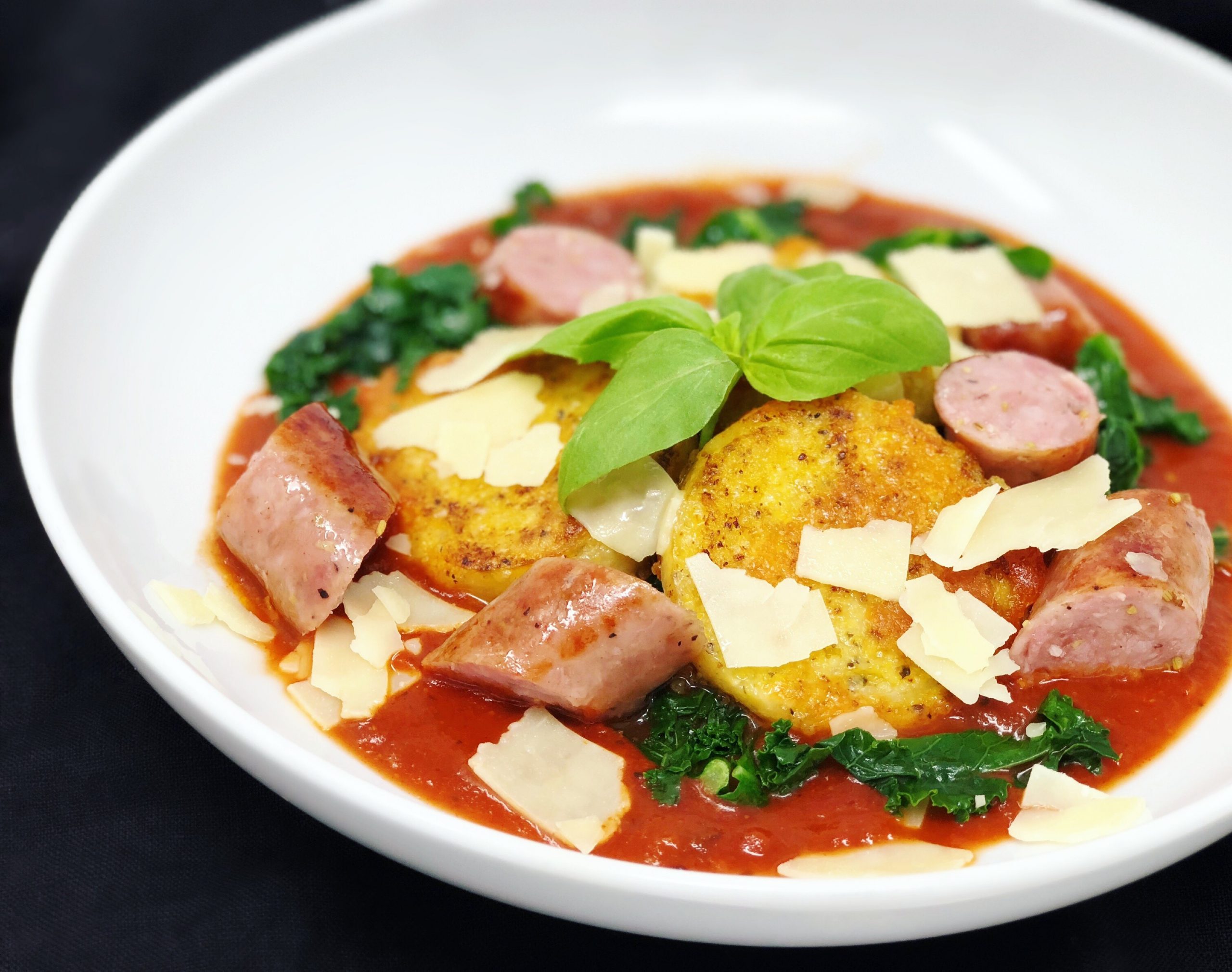 Dish of Parmesan Crusted Polenta with Kale and Sausage