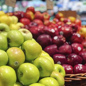 Assortment of many fresh ripe red and green apples displayed beautifully in a grocery store