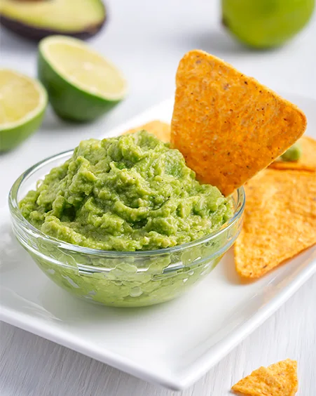 mexican vegan guacamole dip sauce made of avocado served with crunchy nachos