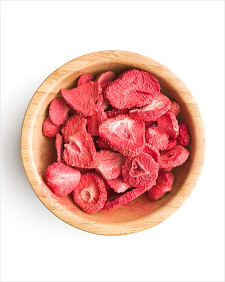 Freeze dried strawberry slices in bowl isolated on white background